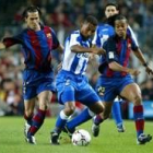 Luis García y Ronaldinho pelean la posesión de un balón que controla Mauro Silva