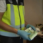 Un policía se incauta de fajos de billetes en un prostíbulo.
