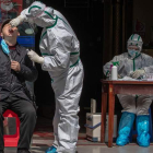 Un habitante de la ciudad de Wuhan, foco de inicio de la pandemia, recibe una prueba para detectar un posible contagio. ROMAN PILIPEY