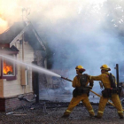 Fotografía cedida por CALFIRE muestra a los bomberos que intentan sofocar el incendio en el condado de Lake, California