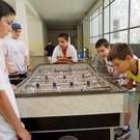 Un grupo de niñso juega al futbolín en el Campus de Baloncesto de Cistierna