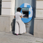 Una clienta saca dinero de un cajero automático de una entidad. RAMIRO