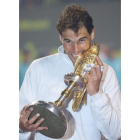 Nadal muerde el trofeo que le acredita como campeón en Doha.