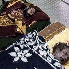 Fotografía de los cuerpos muertos del ex líder libio, Muammar Gaddafi (d), y su hijo Mutassim Gaddafi .