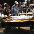Jóvenes y mayores reparten las raciones de  paella popular del barrio La Chimenea. CAMPOS