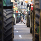 Un hombre pasa entre los tractores que se han manifestado por las calles de Valladolid.