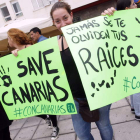 Dos jovenes protestan con pancartas contra las prospecciones petrolíferas en Canarias.