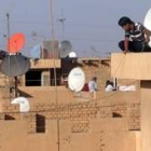 Un iraquí conecta la televisión por satélite en Bagdad