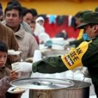Decenas de mexicanos reciben una ración de comida del Ejército