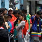 Refugiados venezolanos esperan en lla cola de la oficina de inmigración en Lima.