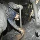 En la imagen, un trabajador recoge el carbón del interior de la mina