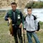 José Manuel Nistal y su hijo Adrián, con una trucha de 2.500 gramos recién pescada