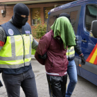 Uno de los dos terroristas detenidos el sábado es conducido por agentes de la policía. EFE