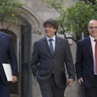 El president Carles Puigdemont, entre el vicepresidente Oriol Junqueras y el conseller Jordi Turull, en el Palau de la Generalitat