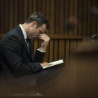 El atleta paralímpico Oscar Pistorius permanece sentado en el banquillo de los acusados durante una nueva sesión de su juicio por el asesinato de su novia Reeva Steenkamp.