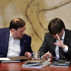 El 'president' Carles Puigdemont y el vicepresidente Oriol Junqueras conversan antes de la reunión del Govern de este martes.