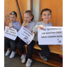 Tres niñas sostienen mensajes de protesta por la comida. L. DE LA MATA