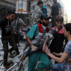 Un hombre saca el cadáver de un niño de una casa alcanzada por un bombardeo en Alepo.