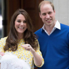 El príncipe William junto a su mujer, Kate Middleton, sonríen felices al abandonar el hospital llevando en brazos a la princesa recién nacida.