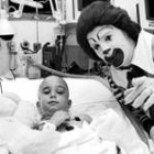 Un payaso visita en el hospital a un niño enfermo