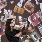 Una mujer posa delante de una pantalla con miles de imágenes de las redes sociales. ANDY RAIN