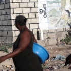 Dos mujeres pasan ante un mural de Oxfam en Puerto Príncipe, Haití.