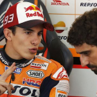 Marc Márquez conversa con un miembro de su equipo en el box de Repsol-Honda, en el circuito de Sepang.