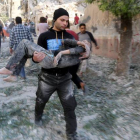 Un hombre traslada a un niño herido en el bombardeo sobre una escuela en Alepo.