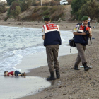 Dos policías turcos trabajan junto al cuerpo sin vida de un niño refugiado ahogado en Turquía.
