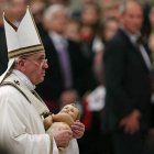 El papa coge al niño Jesús entre sus brazos en la misa.