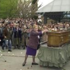 Una mujer deposita flores sobre el féretro de José Couso. A la izquierda, su compañero Jon Sistiaga