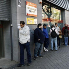 Desempleados ante una oficina del servicio estatal de empleo, en Madrid.