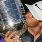 Rory McIlroy besa el trofeo que lo acredita como vencedor del Campeonato de la PGA, en el Club de Golf de Valhalla.