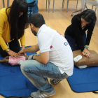 Dos alumnas aprenden a dar masajes cardiacos con dos maniquíes de Cruz Roja. JAVIER SUÁREZ-QUIÑONES