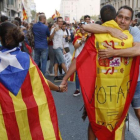 En la imagen una pareja con estelada y bandera española es abrazada por un independentista en Ronda Universitat.