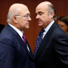 Michel Sapin habla con Luis de Guindos en la reunión del Eurogrupo.