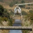 Un helicóptero carga agua en un canal del Bierzo para sofocar un incendio, en una imagen de archivo