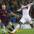 El centrocampista del Barça, Andrés Iniesta, pelea un balón con el delantero del Milan, M’Baye Niang, durante el partido de ayer en el Nou Camp.