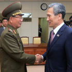 El ministro surcoreano de Unificación, Kim Kwan-jin, a la derecha, da la mano a Hwang Pyong So, responsable norcoreano, tras alcanzar el acuerdo para rebajar la tensión.