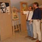 El concejal de Cultura señala al artista una de sus obras en presencia de algunos visitantes