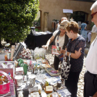 Los visitantes se interesan por algunos de los productos que se pueden adquirir en el mercado.