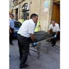 Los servicios funerarios sacan del edificio el cadáver de la mujer
