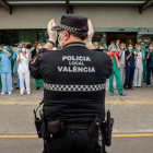 Un policía local y sanitarios del Hospital La Fe de Valencia, durante el aplauso diario. BIEL ALIÑO
