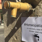 Un cartel promociona homeopatía gratis en una fuente de agua corriente.