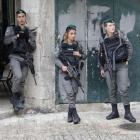 Un palestino camina ante un grupo de soldados israelís en la ciudad antigua de Jerusalén.
