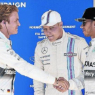 Rosberg, autor de la pole, saluda sonriente a un menos risueño Hamilton (2º) ante Bottas (3º), ayer en Austin.