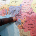 Marc muestra en el mapamundi su país, Camerún, del que huyó en compañía de su pareja, Jean Paul.
