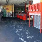 Dos agentes de la Guardia Civil toman muestras del local en la entrada principal, afectada sólamente por el humo.