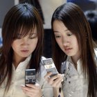 Dos mujeres se muestran mensajes a través de sus ‘smartphones’. MICHAEL REYNOLDS