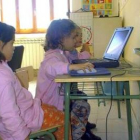 Unas niñas navegan por Internet en el colegio.